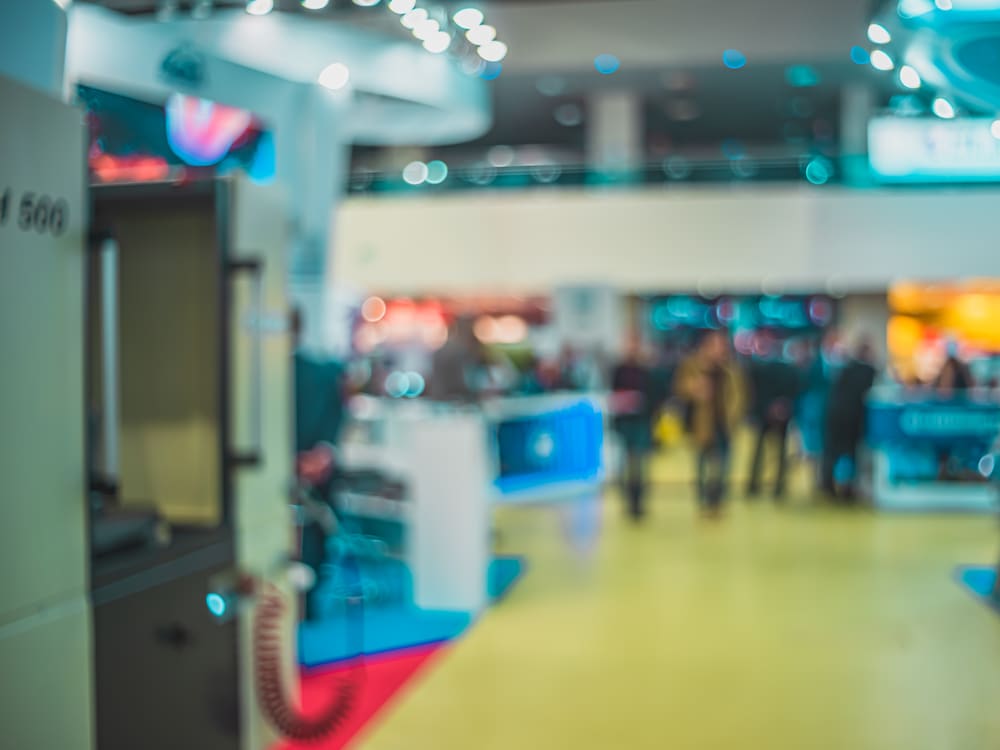 Pasillo de una feria de exposiciones con estands iluminados